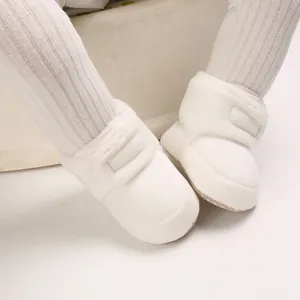 Gros plan détaillé de bottes de neige blanches en peluche avec fermeture velcro.