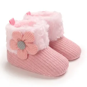 Detail view of pink baby winter snow boots with soft plush lining and cute flower decoration