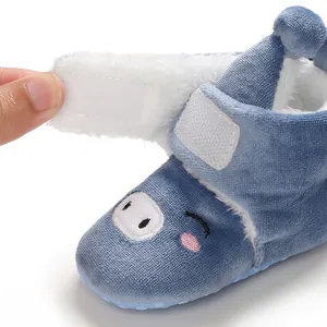 Détail d'une botte d'hiver souple bleue pour bébé avec doublure polaire et velcro.