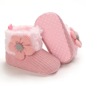 Pink baby winter boots with floral accent and non-slip soft sole detail.