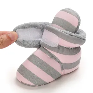 Details von Baby-Winterstiefeln mit rosa Streifen, Plüschfutter und Klettverschluss.