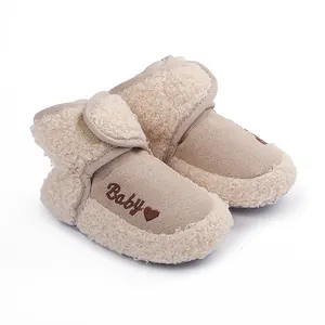 Close-up of beige baby winter boots with soft faux fur trim and Baby heart print.