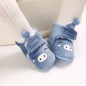 Gros plan sur d'adorables bottes de neige bleues pour bébé avec broderie cochon et doublure
