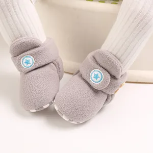 Gedetailleerde close-up van zachte grijze baby fleecelaarzen met een blauw sterontwerp