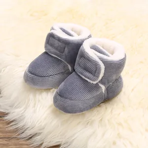 Gros plan détaillé de bottines d'hiver pour bébé en velours côtelé gris avec polaire.