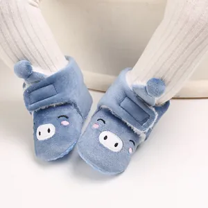 Gros plan sur des bottes de neige bleues pour bébé avec un joli visage de cochon