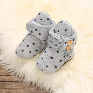 Detailed view of warm grey baby booties with star pattern and soft fleece lining