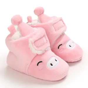 Gros plan de bottes de neige roses pour bébé en peluche avec un motif de cochon mignon et doux