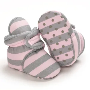 Nahaufnahme warmer gestreifter Babyschuhe mit weichem Fleecefutter und rutschfester Punktsohle