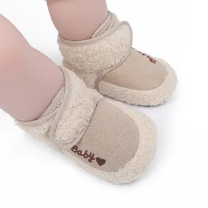 Close-up of beige baby winter boots with soft fleece lining and cute heart embroidery