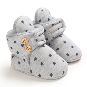 Detalle de botas de nieve para bebé en forro polar gris con estrellas azules y botones