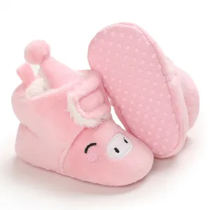 Détail de bottes de neige roses pour bébé avec visage de cochon et semelle antidérapante