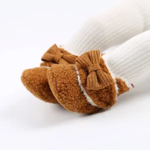 Detailansicht warmer brauner flauschiger Baby-Winterschuhe mit einer süßen Schleife