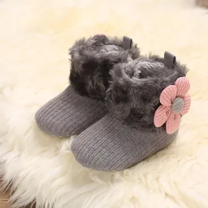 Soft knitted baby winter boots featuring plush fur trim and a pink flower decoration