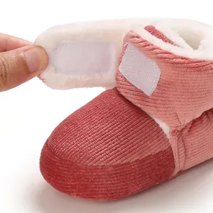 Gros plan du chausson bébé en velours côtelé rose avec doublure polaire blanche.