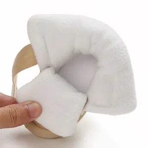 Gedetailleerde macro-opname van de zachte witte fleecevoering in een beige babywinterschoen