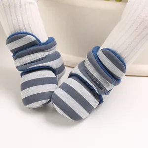 Nahaufnahme von warmen blau-grau gestreiften Baby-Winterstiefeln mit weichem Plüschfutter
