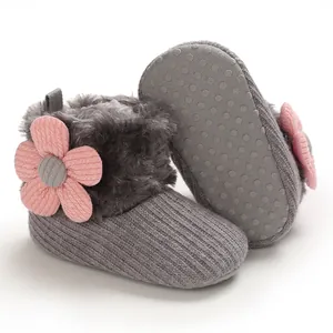 Detailed view of grey knitted baby snow boots featuring a pink flower and soft faux fur trim