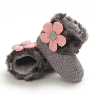 Close-up of warm grey infant snow boots featuring a pink knit flower and soft plush lining