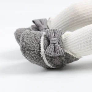 Detailansicht grauer flauschiger Baby-Winterschuhe mit Schleife und weißem Besatz