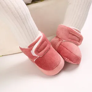 Gros plan de bottines pour bébé en velours côtelé rose avec doublure polaire et velcro