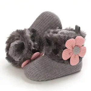 Detailed view of fleece-lined baby snow boots with decorative pink flower