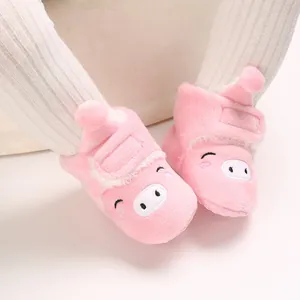 Gros plan de chaussures de marche pour bébé en peluche rose avec motif cochon