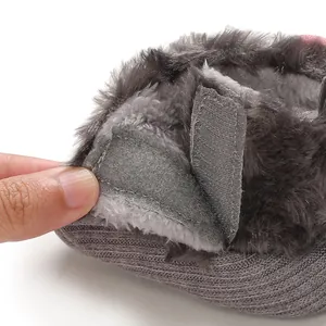 Detailed macro view of the plush warm lining and velcro strap on baby winter shoes