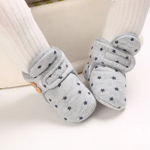 Primer plano de botas de nieve grises para bebé con estrellas azules y forro polar