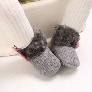 Close-up of grey baby snow boots featuring soft faux fur trim and pink butterfly details