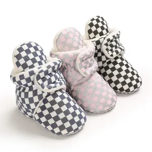 Close-up of three pairs of plush-lined checkerboard baby booties in varied colors