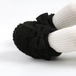 Detail von schwarzen Sherpa-Babyschuhen mit gerippter Schleife und weicher Textur