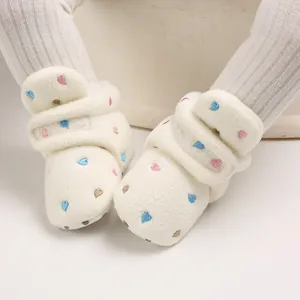 Close-up of soft plush baby winter boots with colorful embroidered heart patterns