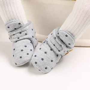 Primer plano de botas de nieve grises para bebé con estrellas azules y forro polar suave