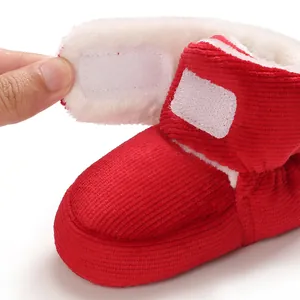 Gros plan de bottes de neige pour bébé en velours côtelé rouge avec doublure en polaire.