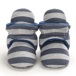Nahaufnahme von warmen gestreiften Babyschuhen mit weichem Fleecefutter und sicherem Klettverschluss.