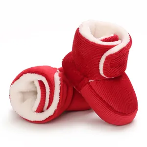 Gros plan sur des bottes d'hiver pour bébé en velours rouge avec doublure en polaire