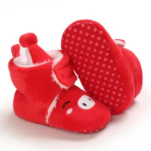 Gros plan sur bottines bébé rouges fourrées avec broderie cochon et semelle antidérapante
