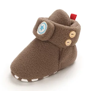 Detailopname van een warme bruine fleece babysneeuwlaars met een sterpatch