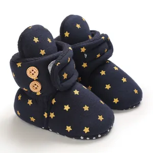 Primer plano de botas de invierno para bebé azul marino con estrellas doradas y vellón