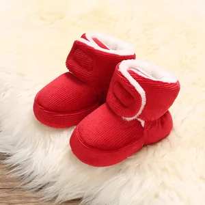 Détail de bottes de neige pour bébé rouges doublées de peluche et texture côtelée