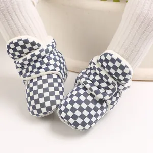 Close-up of baby warm winter boots with blue checkered pattern and fleece lining