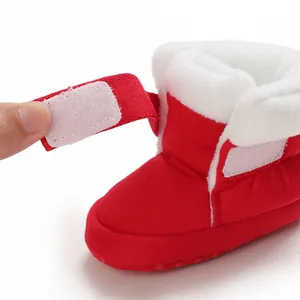 Detail van de klittenbandsluiting op rode baby-winterlaarzen met voering