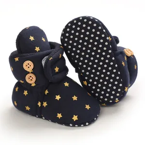 Detalle de las botas de nieve azul marino para bebé con estrellas doradas y suela antideslizante