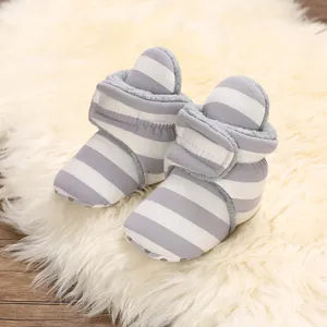 Nahaufnahme von gestreiften Baby-Winterstiefeln mit warmem Fleecefutter und weichen Sohlen.