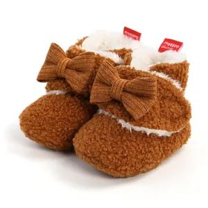 Detailansicht der warmen braunen Plüsch-Babystiefel mit Schleifen und Fleece-Futter