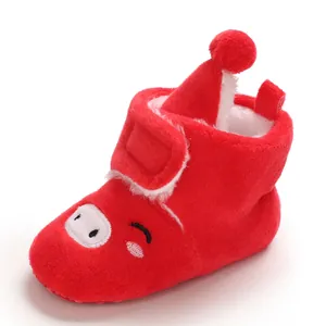 Vue détaillée des bottes de neige rouges en peluche pour bébé avec un motif cochon