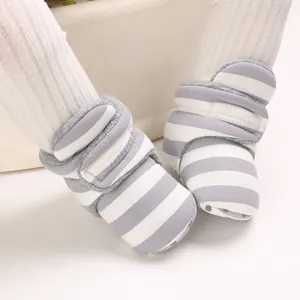 Nahaufnahme von grau gestreiften Baby-Winterschuhen mit Klettverschluss und weicher Sohle