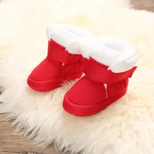 Detail van rode baby winterschoenen met zachte witte imitatiebontvoering en klittenband.