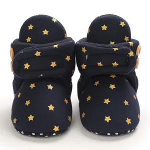 Vista detallada de botas de bebé azul marino con estrellas doradas y forro de felpa